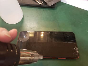 nova3の画面をヒートガンで温め外しているところ