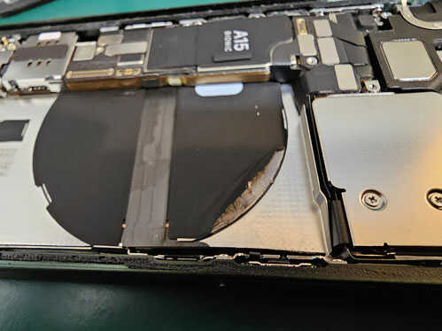 二時的なショート避けるようバッテリーを取り外し内部点検中のiPhone13